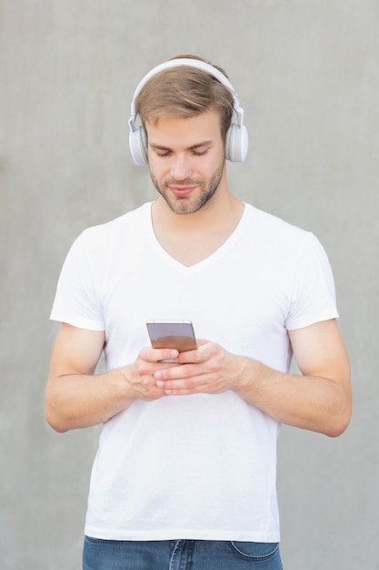 Młody człowiek wybiera listę odtwarzania muzyki mp3 w białej koszuli ze zdjęciem mężczyzny