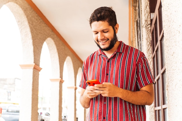 Młody człowiek z Ameryki Łacińskiej za pomocą smartfona w honduras city