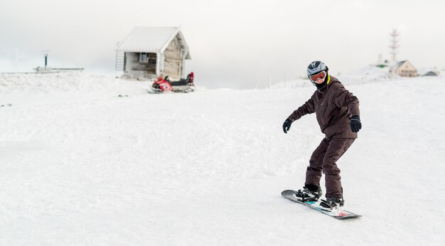 Młody człowiek z snowboardu, ciesząc się zimowy dzień.