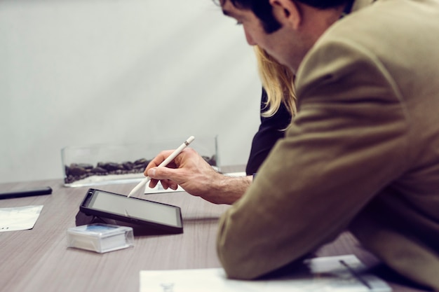 Zdjęcie młody człowiek za pomocą tabletu w biurze spotkania z partnerami biznesowymi