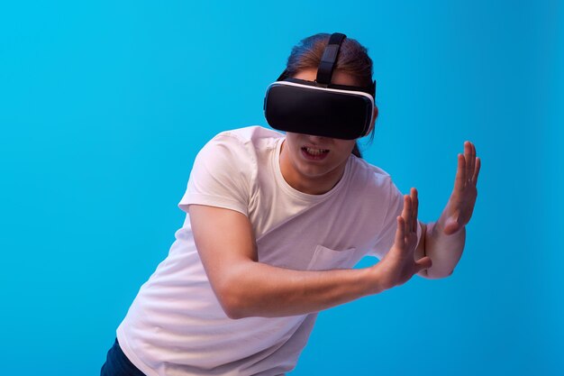 Młody człowiek za pomocą zestawu słuchawkowego wirtualnej rzeczywistości. Gadżety VR