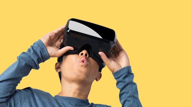 Młody człowiek za pomocą zestawu słuchawkowego wirtualnej rzeczywistości. VR, przyszłość, koncepcja technologii online. na białym tle na żółtym tle. ścieżki przycinające.