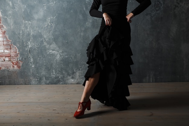Młody dorosły hiszpański kobieta taniec flamenco na szarym tle