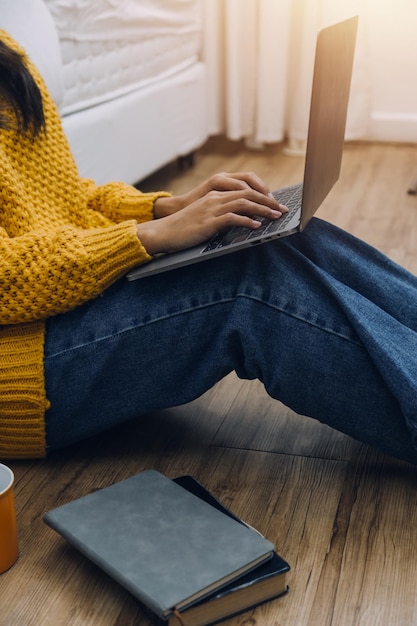 Młody dorosły szczęśliwy uśmiechający się Hiszpanie azjatycki student w słuchawkach rozmawia na czacie online za pomocą laptopa w kampusie uniwersyteckim lub w wirtualnym biurze Studentka college'u ucząca się zdalnie