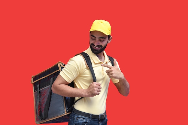 młody dostawca w żółtej koszulce i niosący plecak z jedzeniem na wynos indyjskim pakistańskim modelem