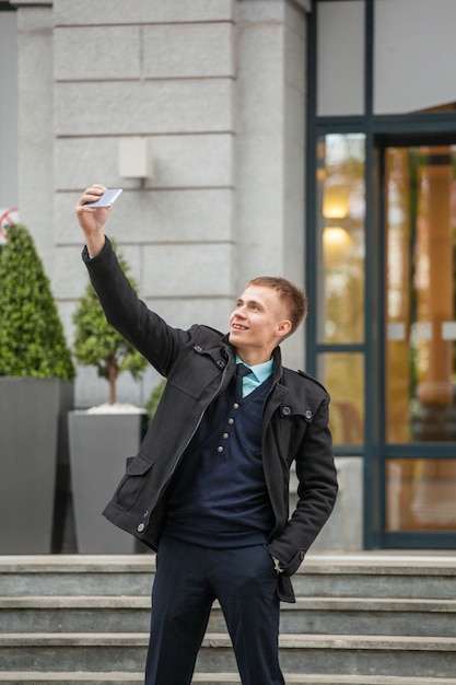 Młody facet z telefonem na zabytkowym budynku