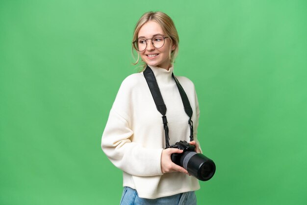 Młody fotograf Angielka na odosobnionym tle z rękami skrzyżowanymi i szczęśliwymi