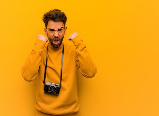 Młody fotograf mężczyzna krzyczy bardzo zły i agresywny