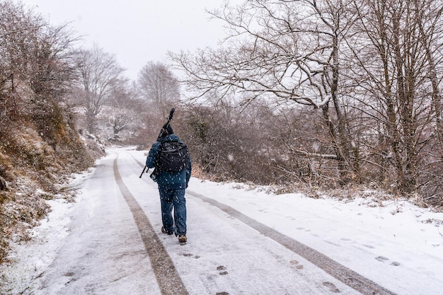 Młody fotograf na zaśnieżonej drodze Mount Aizkorri w Gipuzkoa