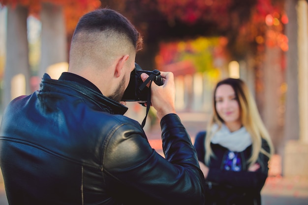 Młody fotograf robi fotografii piękna dziewczyna w parku