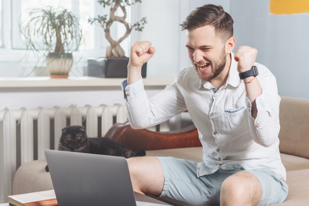 Młody freelancer chętnie korzysta z laptopa podczas pracy w domu