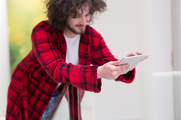 młody freelancer w szlafroku pracujący w domu przy użyciu komputera typu tablet