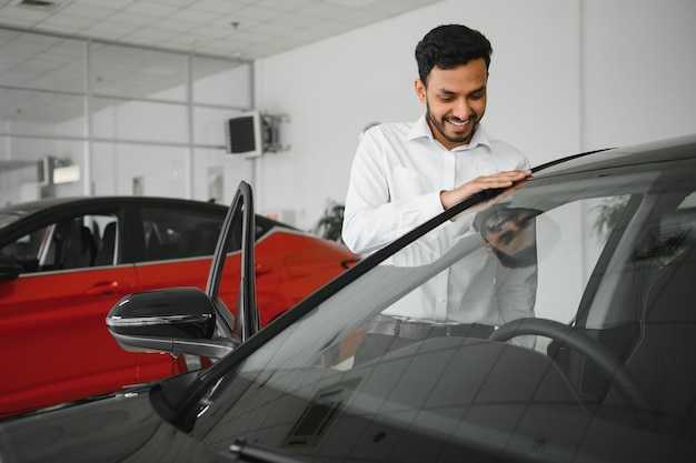 Młody Hindus wybiera nowy samochód w salonie samochodowym