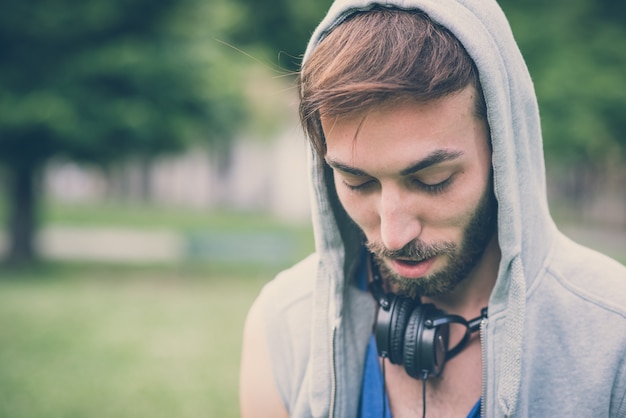 młody hipster gej mężczyzna słuchania muzyki słuchawki