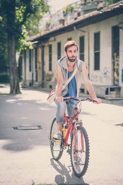 młody hipster gejem z rowerem