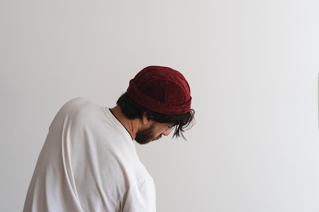 Młody hipster mężczyzna z brodą na sobie czapkę podczas tańca w studio z białym tłem Fotografia artystyczna