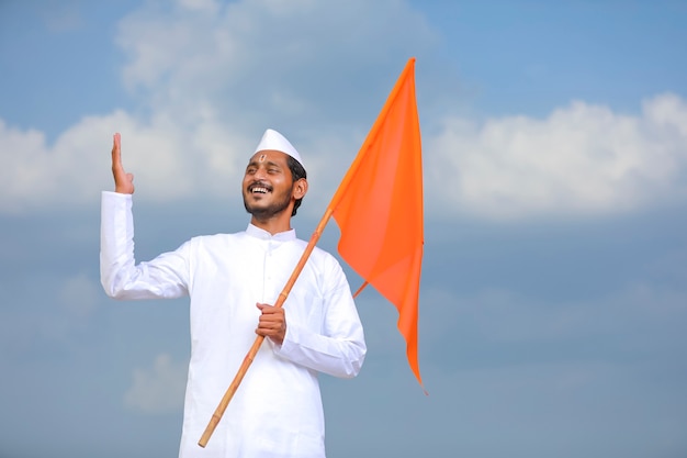 Młody indianin (pielgrzym) w tradycyjnym stroju i macha flagą religijną.