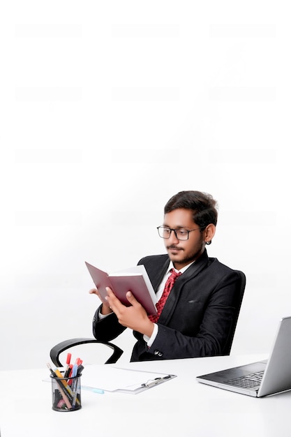 Młody indyjski biznesmen cheaking lub czytanie nabiału w biurze.