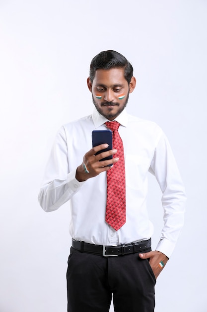 Młody indyjski biznesmen lub pracownik za pomocą smartfona.