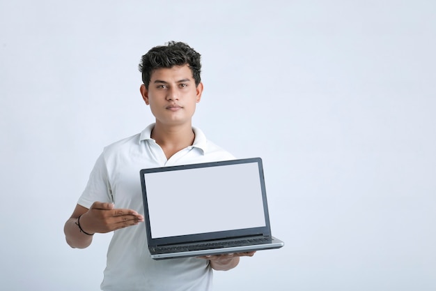 Młody indyjski człowiek sukcesu Wyświetlono ekran laptopa na białym tle.