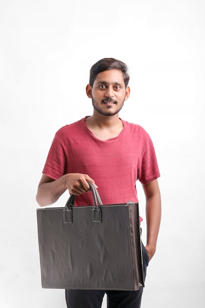Młody indyjski mężczyzna okazujący podekscytowanie z torbami na zakupy