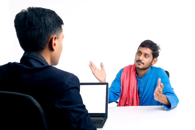 Młody indyjski rolnik rozmawia z bankierem lub oficerem w urzędzie.