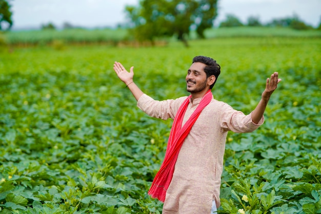 Młody indyjski rolnik w zielonym polu rolnictwa.