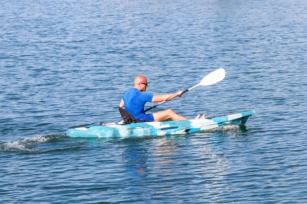 Młody kajakarz Kajak wiosłowy. Sportowiec spływy kajakiem Blue Water.