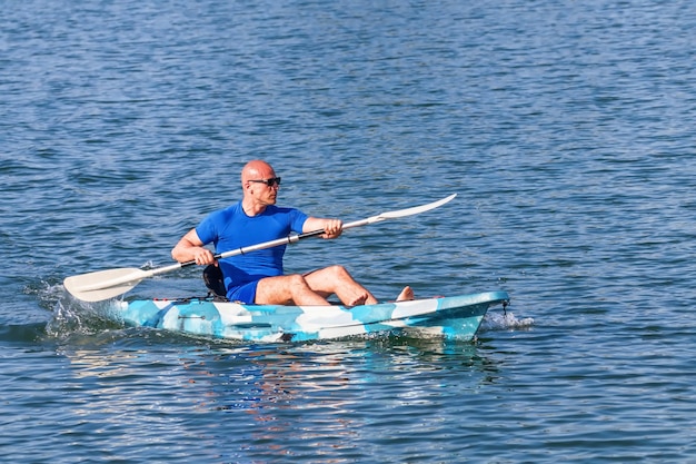 Młody kajakarz Kajak wiosłowy. Sportowiec spływy kajakiem Blue Water.