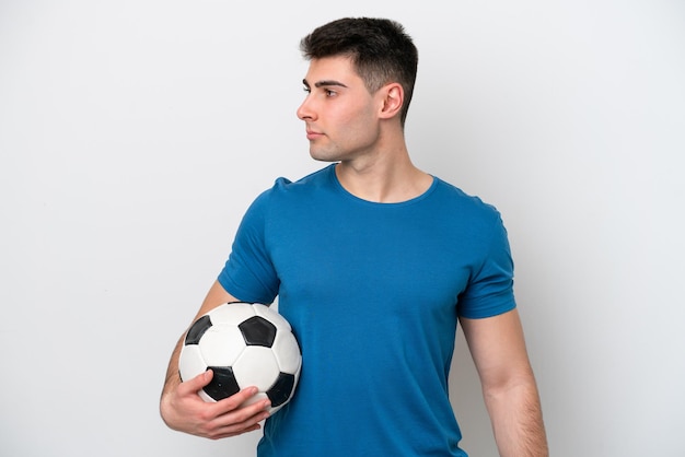 Młody kaukaski mężczyzna na białym tle z piłką nożną