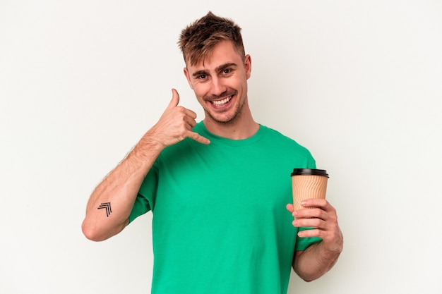 Zdjęcie młody kaukaski mężczyzna trzyma kawę na wynos na białym tle na białym tle pokazując gest połączenia z telefonu komórkowego palcami.