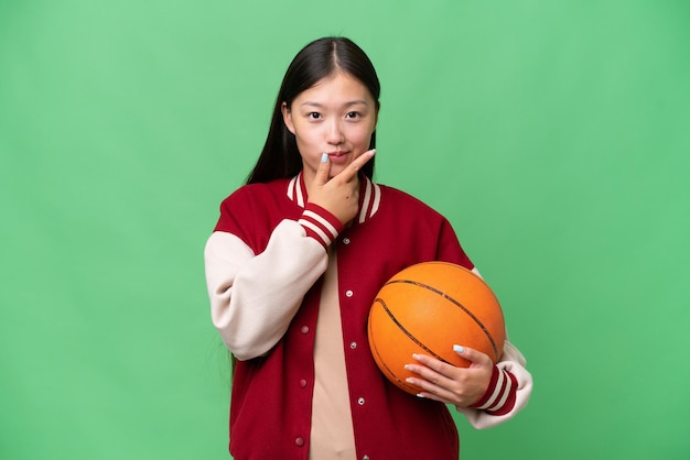 Młody koszykarz azjatycka kobieta na odosobnionym tle myślenia