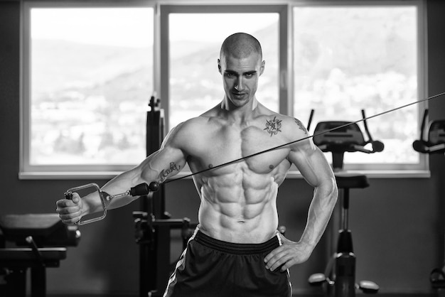 Zdjęcie młody kulturysta fitness mięśni wykonujący ciężkie ćwiczenia na triceps na siłowni