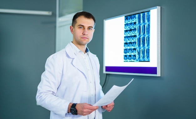 Młody lekarz badający kliszę rentgenowską w diafanoskopie