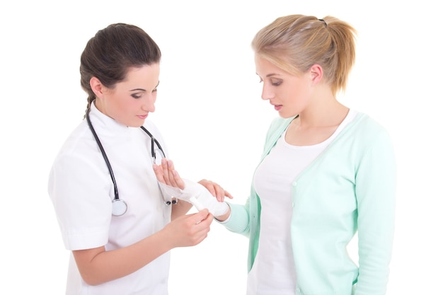 Młody lekarz bandażuje kobiecą rękę na białym tle
