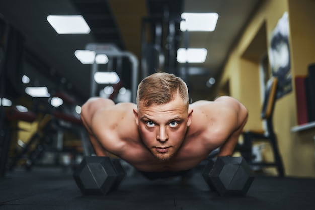 Młody Lekkoatletyczny Mężczyzna Robi Pompki W Siłowni Muskularny I Silny Facet ćwiczeń