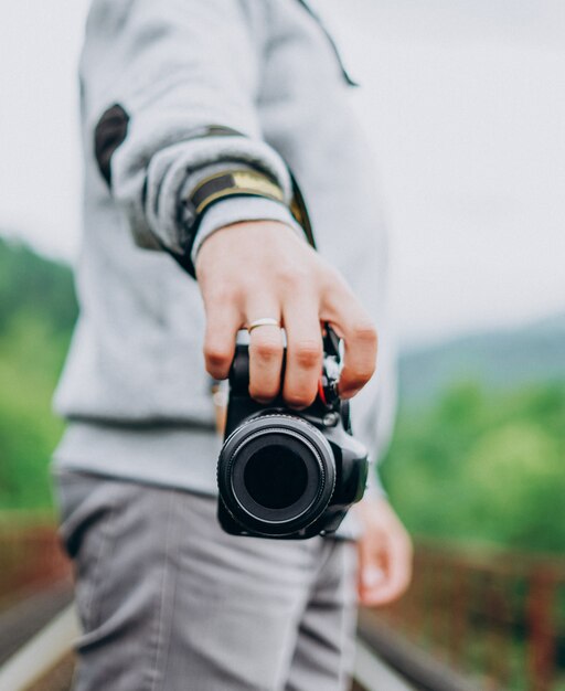 Młody męski fotograf trzyma kamerę