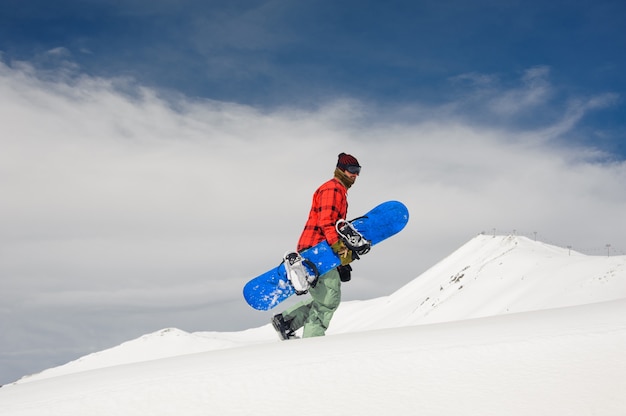 Młody Męski Snowboarder Chodzi W Górę Wzgórza