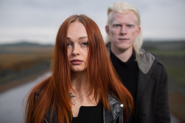 Młody mężczyzna albinos i ruda dziewczyna stoją na wiejskiej drodze