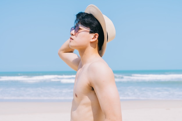 Młody mężczyzna azjatyckich spaceru na plaży
