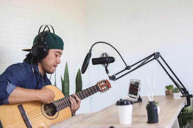 Młody Mężczyzna Azji Gra Na Gitarze I Nagrywania Muzyki W Domu