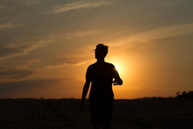 młody mężczyzna biegający i pokazujący ruch o zachodzie słońca