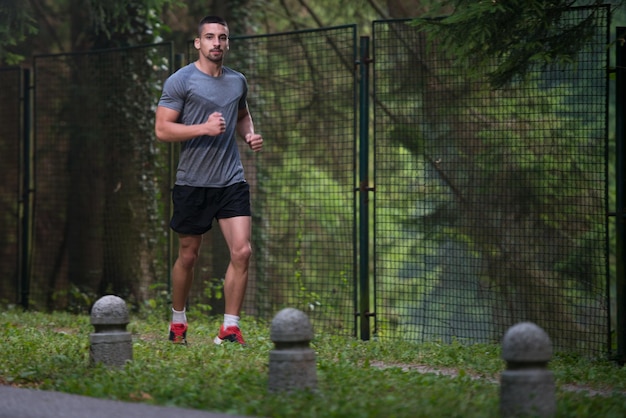 Młody mężczyzna biegający w zalesionym terenie leśnym - trening i ćwiczenia na wytrzymałość Trail Run Marathon - koncepcja zdrowego stylu życia Fitness