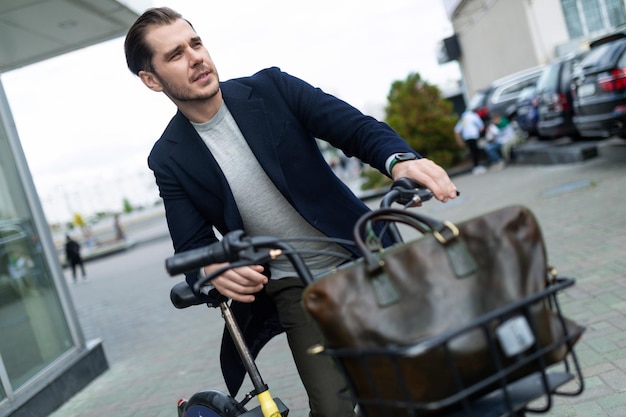 Młody mężczyzna biznesmen jeździ rowerem do pracy koncepcja ochrony środowiska bezpiecznym środkiem transportu
