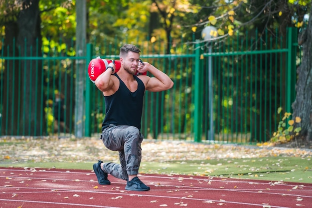 Młody mężczyzna fitness pracuje na świeżym powietrzu Przystojny kulturysta trenuje na świeżym powietrzu