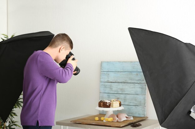 Młody mężczyzna fotografujący jedzenie w profesjonalnym studiu fotograficznym