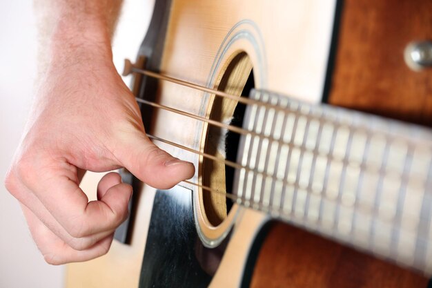 Zdjęcie młody mężczyzna grający na gitarze akustycznej z bliska