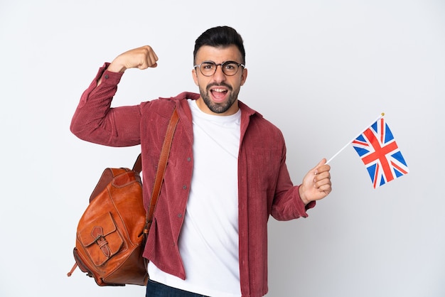 Młody mężczyzna hiszpanin trzyma flagę Wielkiej Brytanii robi silny gest