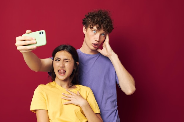 Młody mężczyzna i dziewczyna w kolorowych koszulkach w młodzieżowym stylu telefonu