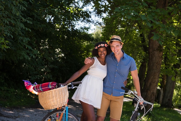 młody mężczyzna i piękna Afroamerykanka ciesząca się przejażdżką rowerową na łonie natury w słoneczny letni dzień